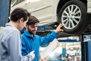 Vehicle maintenance servicer explain car condition and expense to customer in garage